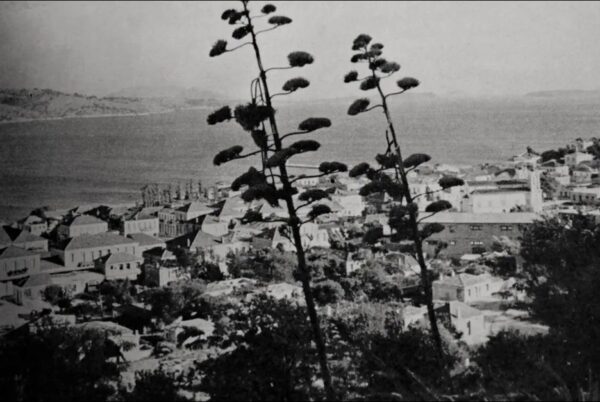 Ασπρόμαυρη θέα σε παραθαλάσσια πόλη με αθάνατους στο πρώτο πλάνο